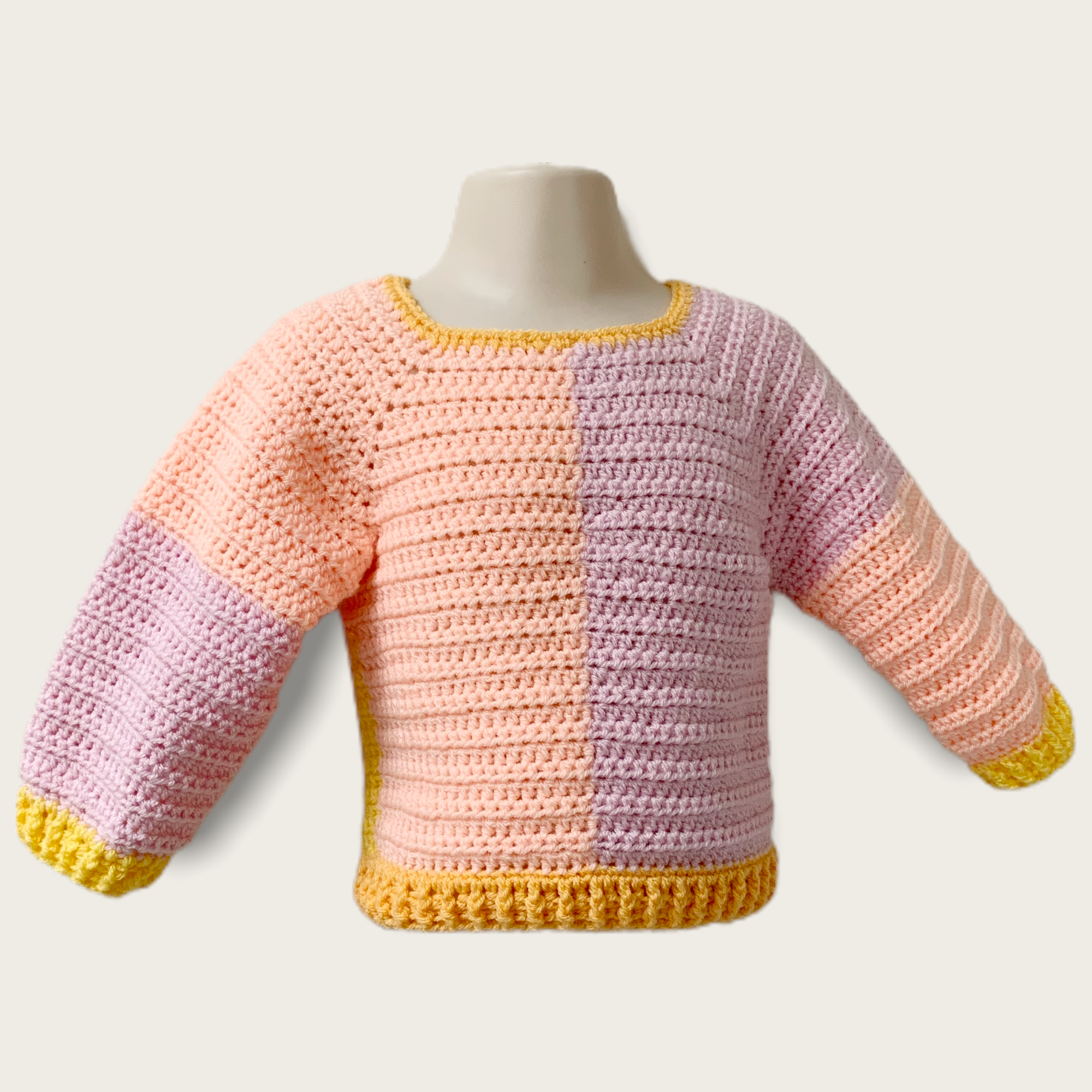 Front of Reese sweater sample for 18 months in yellow, pink, orange colours